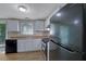 A functional kitchen with white cabinets, black appliances, and a view of the outdoors at 5295 Old Trail Cir, Stone Mountain, GA 30088