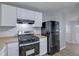 Well-lit kitchen with stainless steel oven and fridge, featuring vinyl floors at 5295 Old Trail Cir, Stone Mountain, GA 30088