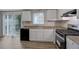 Bright kitchen with stainless steel appliances, white cabinets and sliding glass doors to the yard at 5295 Old Trail Cir, Stone Mountain, GA 30088