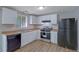A well-lit kitchen featuring white cabinets, black appliances, and light-colored countertops at 5295 Old Trail Cir, Stone Mountain, GA 30088