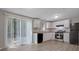 A bright kitchen with white cabinets, black appliances, and sliding doors to the patio at 5295 Old Trail Cir, Stone Mountain, GA 30088