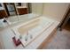 Bright bathroom features a large soaking tub with tile surround and modern fixtures at 118 Heritage Way, Peachtree City, GA 30269