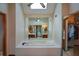 Serene bathroom features a large soaking tub, mirrored wall, and plenty of natural light at 118 Heritage Way, Peachtree City, GA 30269