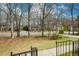 Street view of a brick house with black shutters surrounded by mature trees at 118 Heritage Way, Peachtree City, GA 30269
