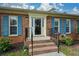Classic brick home entrance with blue shutters and neat landscaping at 118 Heritage Way, Peachtree City, GA 30269