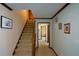 Inviting foyer with staircase, neutral walls, and wood trim detailing leading to other rooms at 118 Heritage Way, Peachtree City, GA 30269