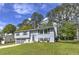 Gray split-level home with a two-car garage, lush lawn, and well-maintained landscaping at 1460 Parkmont Dr, Roswell, GA 30076