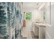 Cozy bathroom featuring a decorative shower curtain, vanity with ample storage, and a window at 2162 Brookview Nw Dr, Atlanta, GA 30318
