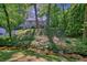 Charming two-story home featuring a stone facade, red door, and lush greenery at 2162 Brookview Nw Dr, Atlanta, GA 30318