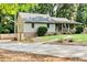 Home with a long driveway leading to a side entrance, enhanced by professional landscaping and mature trees at 3255 Sutcliffe Nw Rdg, Marietta, GA 30064