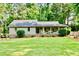 Charming single-story home with a well-manicured lawn, inviting porch, and mature trees, offering a serene curb appeal at 3255 Sutcliffe Nw Rdg, Marietta, GA 30064