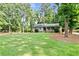 Expansive front yard featuring a well-maintained lawn and mature trees, complementing the home's idyllic setting at 3255 Sutcliffe Nw Rdg, Marietta, GA 30064