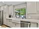 Renovated kitchen with white cabinets, stainless appliances, and a farmhouse sink with a view of the backyard at 3255 Sutcliffe Nw Rdg, Marietta, GA 30064