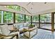 Relaxing screened porch area with wood furniture, ceiling fan, and views of the surrounding greenery at 3255 Sutcliffe Nw Rdg, Marietta, GA 30064