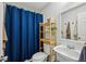 This stylish bathroom includes a blue shower curtain and a nice vanity mirror at 1634 Ponce De Leon Ne Ave # 208, Atlanta, GA 30307