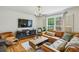 Bright living room features a brown leather sofa, modern lighting, and a view to the outside at 1634 Ponce De Leon Ne Ave # 208, Atlanta, GA 30307