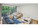 Cozy living area with large windows overlooking a lush backyard and comfortable furniture at 1634 Ponce De Leon Ne Ave # 208, Atlanta, GA 30307