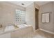 Bright bathroom featuring a tiled tub, shower, and glass block window at 183 Whitefoord Ne Ave, Atlanta, GA 30307