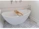 Elegant freestanding bathtub with a wooden shelf, modern fixtures, and decorative tile flooring at 2840 Alpine Rd, Atlanta, GA 30305