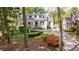Charming white home with a manicured lawn, blooming flowers, and mature trees along a winding driveway at 2840 Alpine Rd, Atlanta, GA 30305