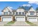 Charming townhome with white brick exterior, a two-car garage, and well manicured lawn at 4090 Cavalier Way, Duluth, GA 30097