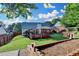 Landscaped backyard featuring a spacious lawn, patio, and wooden retaining wall at 755 James Ridge Dr, Lawrenceville, GA 30045