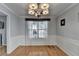 Formal dining room with hardwood floors, decorative chandelier, wainscoting and lots of natural light at 755 James Ridge Dr, Lawrenceville, GA 30045