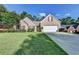 Charming brick home featuring a well-manicured lawn and a two-car garage and bright yellow front door at 755 James Ridge Dr, Lawrenceville, GA 30045