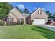 Lovely brick home featuring a well-manicured lawn and a two-car garage and bright yellow front door at 755 James Ridge Dr, Lawrenceville, GA 30045