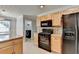 Kitchen features stainless appliances, wood cabinets, and view of laundry area at 755 James Ridge Dr, Lawrenceville, GA 30045