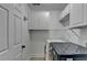 Bright laundry room with washer, dryer, white cabinets, and shelving at 755 James Ridge Dr, Lawrenceville, GA 30045