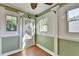 Bright sunroom showcasing tile floor, green accent wall, and windows providing scenic backyard view at 755 James Ridge Dr, Lawrenceville, GA 30045
