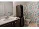 Well-appointed bathroom featuring a modern vanity, coordinated cabinet, and stylish shower curtain at 109 Auburn Crossing Dr, Auburn, GA 30011