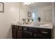 Bathroom featuring double sinks with white countertops and dark wood cabinets at 109 Auburn Crossing Dr, Auburn, GA 30011