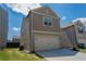 Side angle of two-story home featuring gray siding, green grass, and a two car garage at 109 Auburn Crossing Dr, Auburn, GA 30011