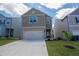 Two-story home with gray siding, concrete driveway and a two car garage at 109 Auburn Crossing Dr, Auburn, GA 30011