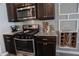 Modern kitchen featuring stainless steel appliances, dark cabinets, and decorative backsplash at 109 Auburn Crossing Dr, Auburn, GA 30011