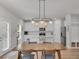 Bright dining area with modern light fixtures, white cabinets, and stainless steel appliances at 2099 Easterwood Ter, Decatur, GA 30032