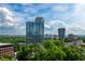 Beautiful view of a modern high-rise building surrounded by trees, under a partly cloudy sky at 2828 Peachtree Nw Rd # 1501, Atlanta, GA 30305