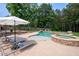 Beautiful backyard oasis featuring a luxurious pool, spa, and lounge area at 440 Scott Farm Dr, Powder Springs, GA 30127