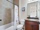 Cozy bathroom with a shower and tub combination, paired with a wood vanity and a floral shower curtain at 440 Scott Farm Dr, Powder Springs, GA 30127