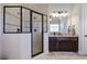 Well-lit bathroom featuring a glass enclosed shower and dark wood vanity with decorative tile accents at 440 Scott Farm Dr, Powder Springs, GA 30127