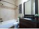 Cozy bathroom with a bathtub, dark wood vanity with black countertop, and a decorative mirror at 440 Scott Farm Dr, Powder Springs, GA 30127