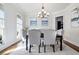 Elegant dining room featuring hardwood floors, a modern chandelier, and stylish upholstered chairs at 440 Scott Farm Dr, Powder Springs, GA 30127