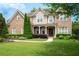 Beautiful two-story brick home with a manicured lawn and covered front porch at 440 Scott Farm Dr, Powder Springs, GA 30127
