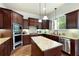 Spacious kitchen with stainless appliances, granite countertop, center island, and rich wood cabinetry at 440 Scott Farm Dr, Powder Springs, GA 30127