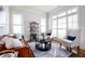 Cozy living room with leather sofa, area rug, ample windows, and natural light at 440 Scott Farm Dr, Powder Springs, GA 30127