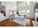 Open-concept living area with high ceilings, hardwood floors, fireplace, and large windows with backyard views at 440 Scott Farm Dr, Powder Springs, GA 30127