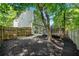 Fenced backyard featuring a wooden deck, sliding glass doors, mulch beds, and scattered trees, offering a secluded atmosphere at 562 Poplar Bnd, Canton, GA 30114