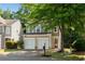 Inviting home exterior with a double garage, tree, and well-kept lawn at 562 Poplar Bnd, Canton, GA 30114